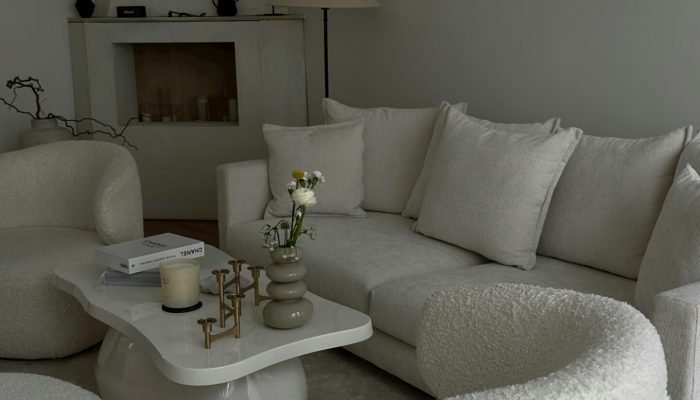 A living room with white furniture and a fireplace